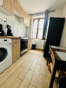 kuchnia z pralką i drewnianą podłogą w obiekcie Le cosy du Panier w Marsylii