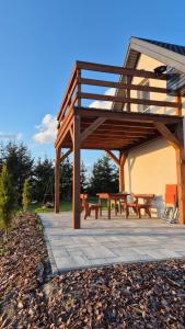 a pavilion with benches and tables on a patio at Mazurski Zakątek Orzyny in Orzyny