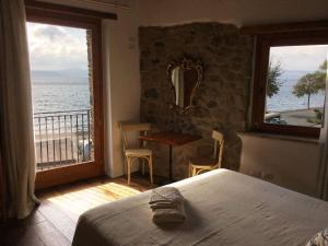 1 dormitorio con cama y vistas al océano en Al Vicolo dei Pescatori, en Anguillara Sabazia