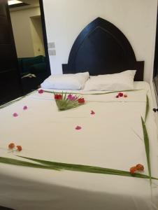 a white bed with flowers on it with a mirror at Villa Silia in Sharm El Sheikh