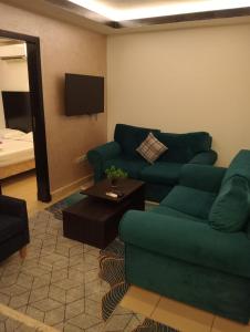 a living room with a green couch and a tv at Villa Silia in Sharm El Sheikh