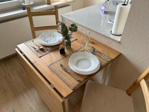 a table with a plate and wine glasses on it at Ferienwohnung Ritthoff Perlebucht - mit Strandkorb am Meer und kostenloser Eintritt ins Schwimmbad in Büsum