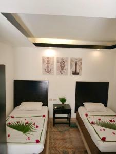 two beds sitting in a room with a table at Villa Silia in Sharm El Sheikh
