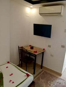 a room with a table and a tv on a wall at Villa Silia in Sharm El Sheikh