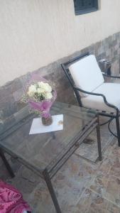 a glass table with a vase of flowers and a chair at Villa Silia in Sharm El Sheikh