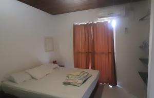 um pequeno quarto com uma cama e uma janela em Pousada Splash em Florianópolis