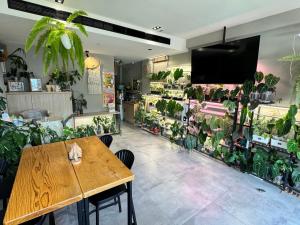 a restaurant with a table and a lot of plants at 厝True Hub旅店 in Nanwan