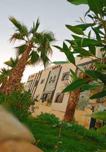 a building with palm trees in front of it at Villa Silia in Sharm El Sheikh