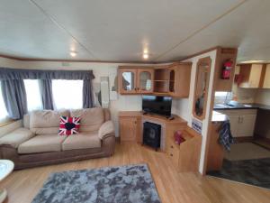 a living room with a couch and a stove in a caravan at G26 kirbys Retreat 2 in Skegness