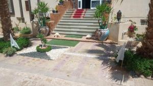 a house with a staircase with palm trees and plants at Villa Silia in Sharm El Sheikh