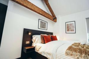 ダービーにあるNo46 Stylish City Studio Apartment, By DerBnBのオレンジ色の枕が付いた大きなベッドのある寝室