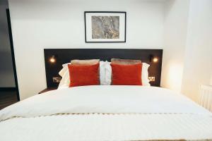 ダービーにあるNo46 Stylish City Studio Apartment, By DerBnBのオレンジ色の枕が付いた大きな白いベッドのある寝室 +8枚の写真
