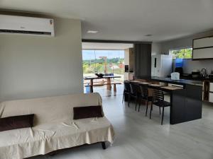 a living room and kitchen with a couch and chairs at Taipu House Fantástica com piscina em condomínio in Barra Grande