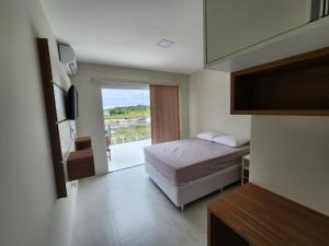 a hotel room with a bed and a balcony at Taipu House Fantástica com piscina em condomínio in Barra Grande +65 photos