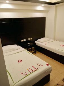 a room with two beds with red flowers on the sheets at Villa Silia in Sharm El Sheikh