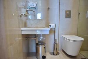 a bathroom with a sink and a toilet at Sykea Luxury Apartment in Xylokastro +64 photos