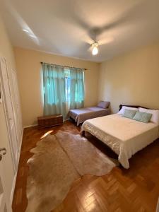 a bedroom with a bed and a couch and a window at Casa Amarela in Conservatória