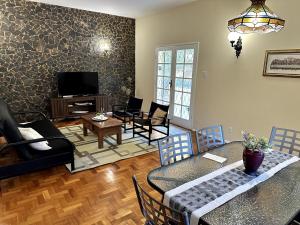 a living room with a table and chairs and a television at Casa Amarela in Conservatória