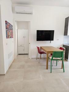 a living room with a table and chairs and a television at Da Camilla in Cagliari