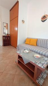 a living room with a couch and a table at Ammoudeli Coastal Escape in Plomari