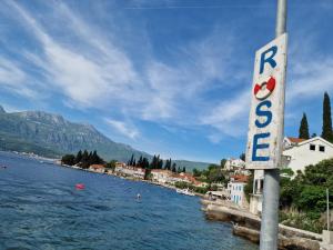 a sign on the side of a body of water at Agape Rose Hotel in Tivat