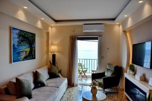 a living room with a couch and a television at Sykea Luxury Apartment in Xylokastro