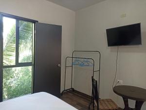 a bedroom with a bed and a television on the wall at Hotel & Hostal 230 in Valladolid
