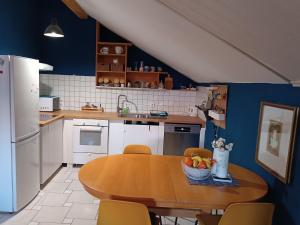 a kitchen with a wooden table and a blue wall at Open Space - Tisljaric in Zagreb
