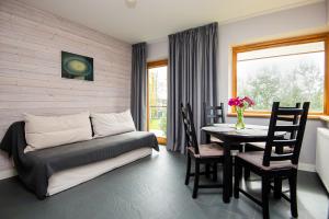 a living room with a couch and a table with chairs at Guesthouse Žilvičių g. 5 in Palanga