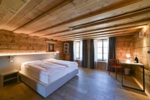 a bedroom with a bed and a wooden ceiling at Hotel Maloja Kulm in Maloja