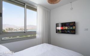埃拉特Luxury Apartments And Studios At Sea Side By Rently的一间卧室，墙上有一张床和一台电视