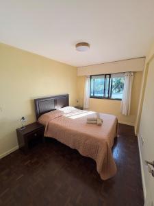 a bedroom with a bed with two towels on it at Apartamento con vista al Rio y frente a la playa in Colonia del Sacramento