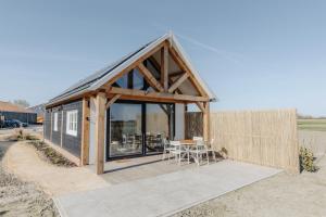 a small cabin with a table and chairs at De ZonneWij in Grijpskerke