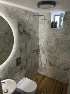 a bathroom with a shower and a toilet and a sink at Piccadilly Apartment Patras in Patra