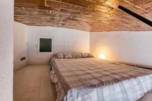 a bedroom with a large bed with a wooden ceiling at Sa Calma - Cap Sa Sal Begur in Isla Negra