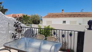 een tafel en stoelen op een balkon met een hek bij Carmen Casa Helena in Nerja +7 foto's