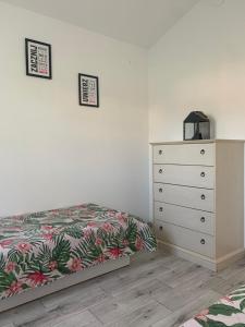a bedroom with a dresser and a bed with a bedspread at Pachnący Jaśmin in Zwierzyniec +11 photos