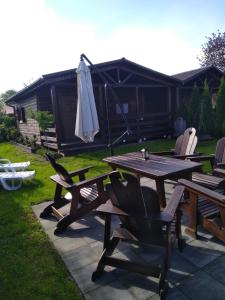 a picnic table and chairs with an umbrella in a yard at Pachnący Jaśmin in Zwierzyniec