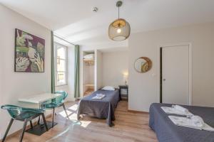 a living room with a bed and a table and a couch at Hôtel Patricia - Strasbourg Hyper Centre in Strasbourg