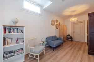a living room with a blue chair and a book shelf at Hôtel Patricia - Strasbourg Hyper Centre in Strasbourg