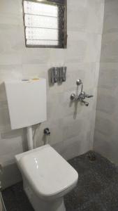 Un baño con inodoro blanco y ventana. en The Malshej Mist, en Ghātghar 33 fotos más