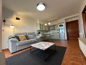 a living room with a couch and a table at Relax, sea and mountains in A Guarda