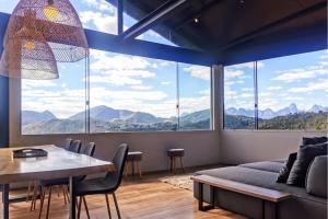 ein Wohnzimmer mit Tisch und großem Fenster in der Unterkunft Lux 28 - Casa moderna piscina aquecida e vista in Teresópolis