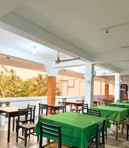 an empty restaurant with green tables and chairs at Haus Athula in Bentota