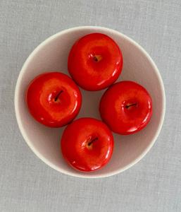 four red apples in a white bowl on a table at At the Side of the Castle in Plaka Milou +17 photos