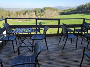 a group of chairs and tables on a deck at La Maison Rose Bertignat in Bertignat +6 photos