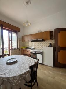 una cocina con mesa y una cocina con refrigerador en Casa Dalì, en Pianillo