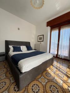 Un dormitorio con una cama grande con sábanas azules y blancas. en Casa Dalì, en Pianillo
