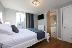 a bedroom with a white bed and a bathroom at Swift Apartments York in York