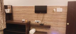 a room with a desk and a television on a wall at Prantik Retreat in Bāgnān
